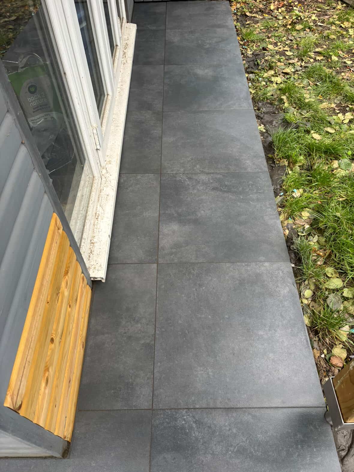 Dark grey porcelain patio with clean joint lines in a Derby garden