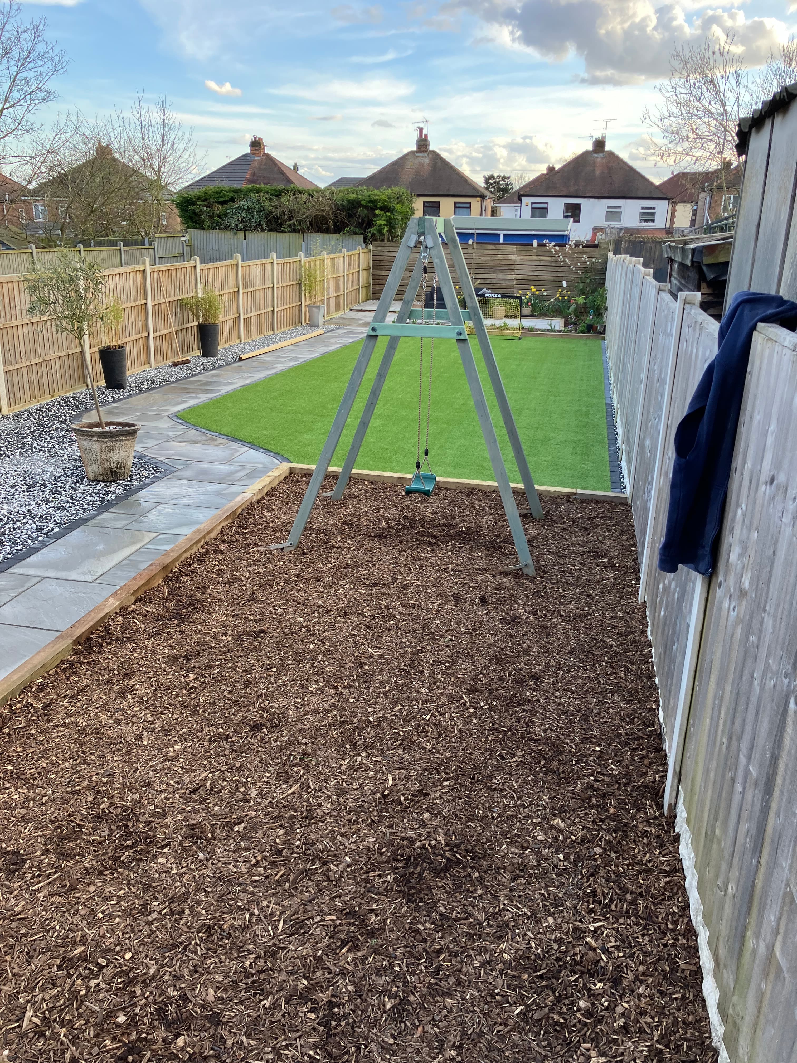 Artificial grass installation laid alongside the sandstone patio in Derby