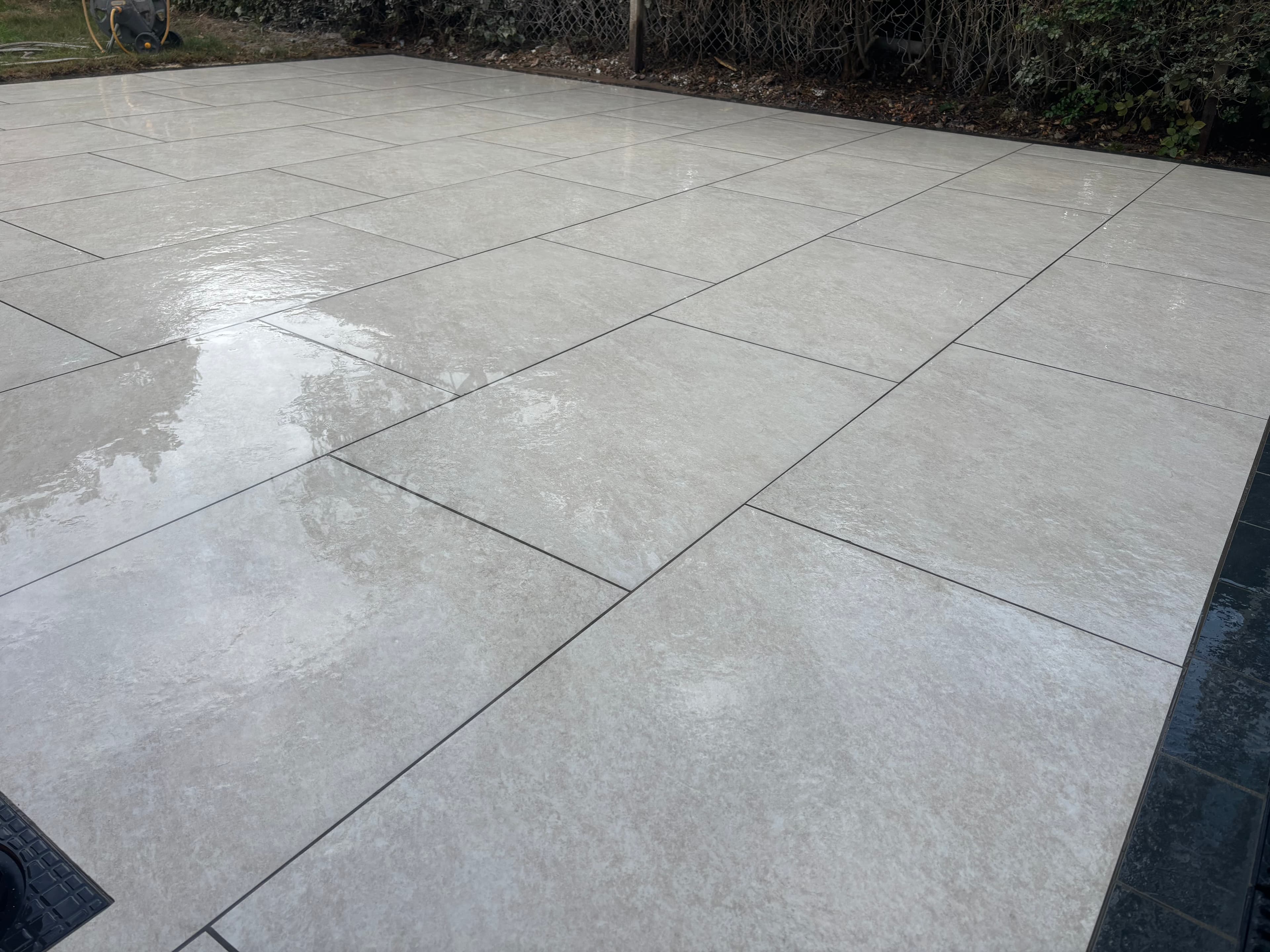Completed porcelain patio viewed from the house showing the full layout