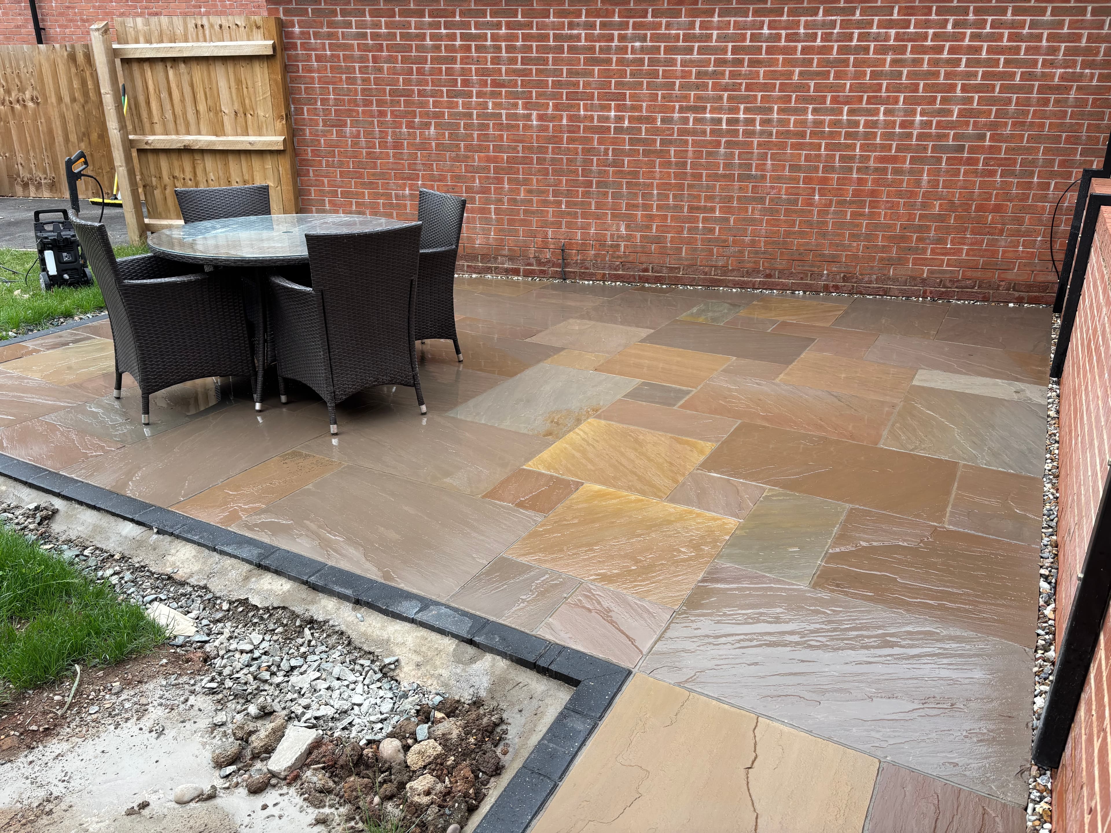 Completed rear garden with two patio areas and brick features in Mickleover
