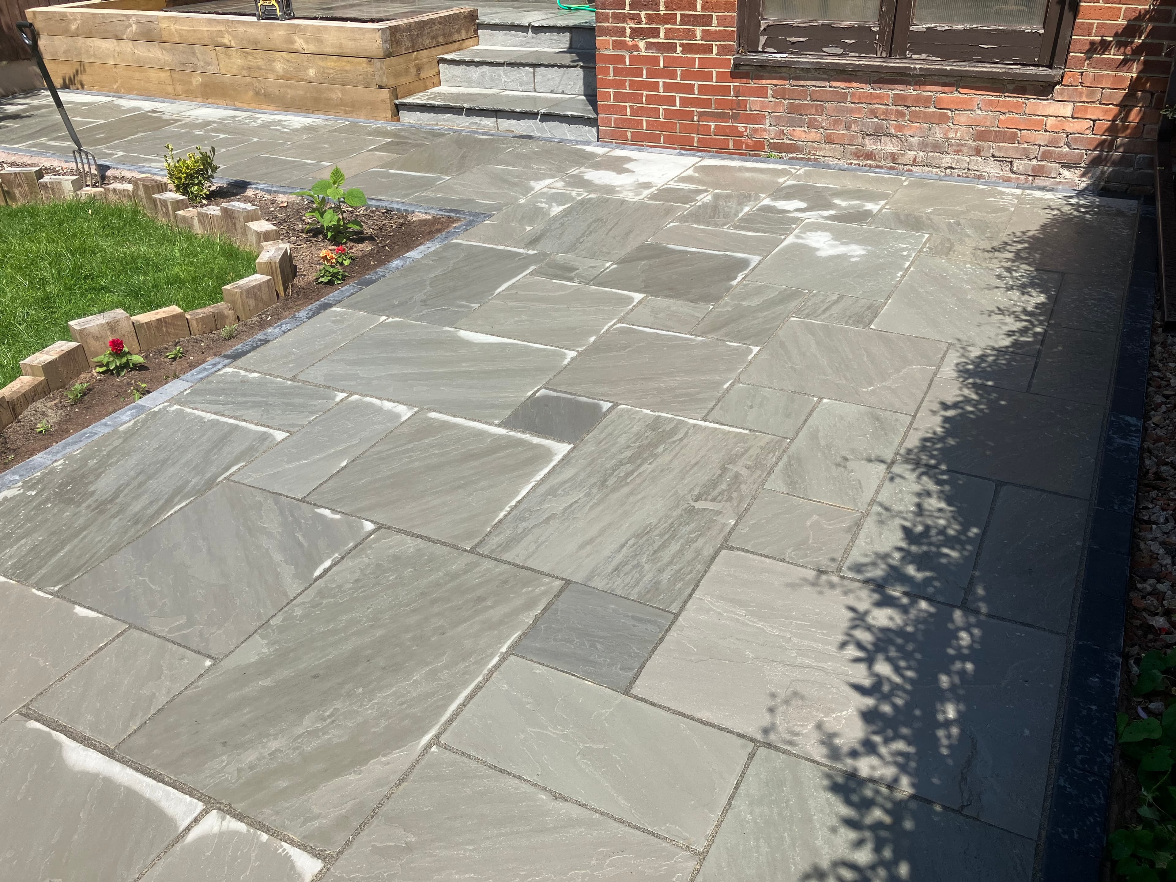 Granite block edging framing the natural stone patio border