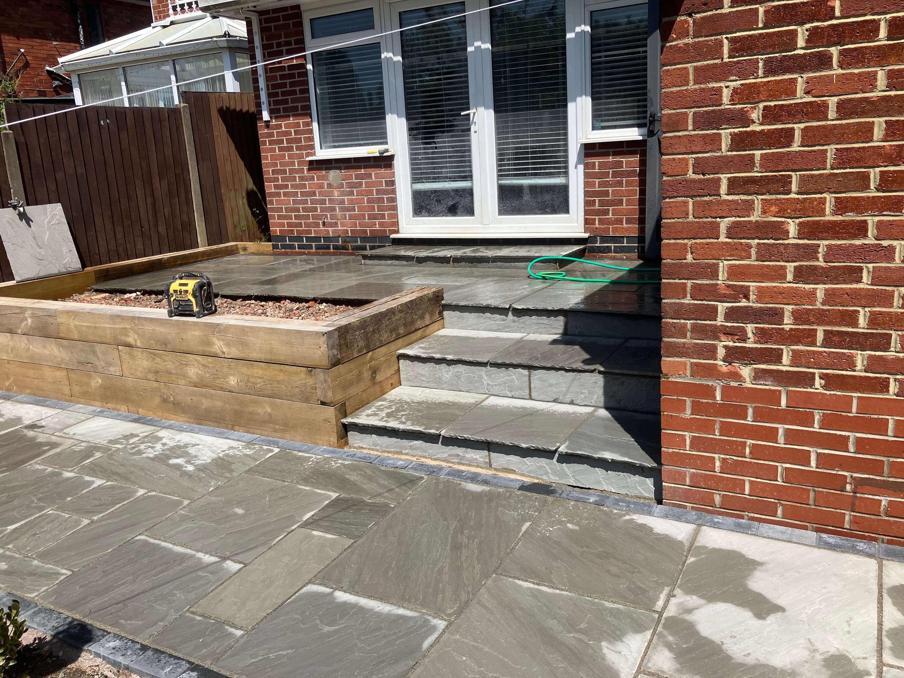 Overview of the multi-level patio showing the step and planter layout